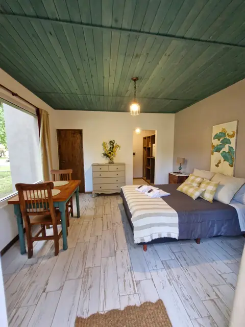 Habitación con techo de madera verde y detalles artesanales