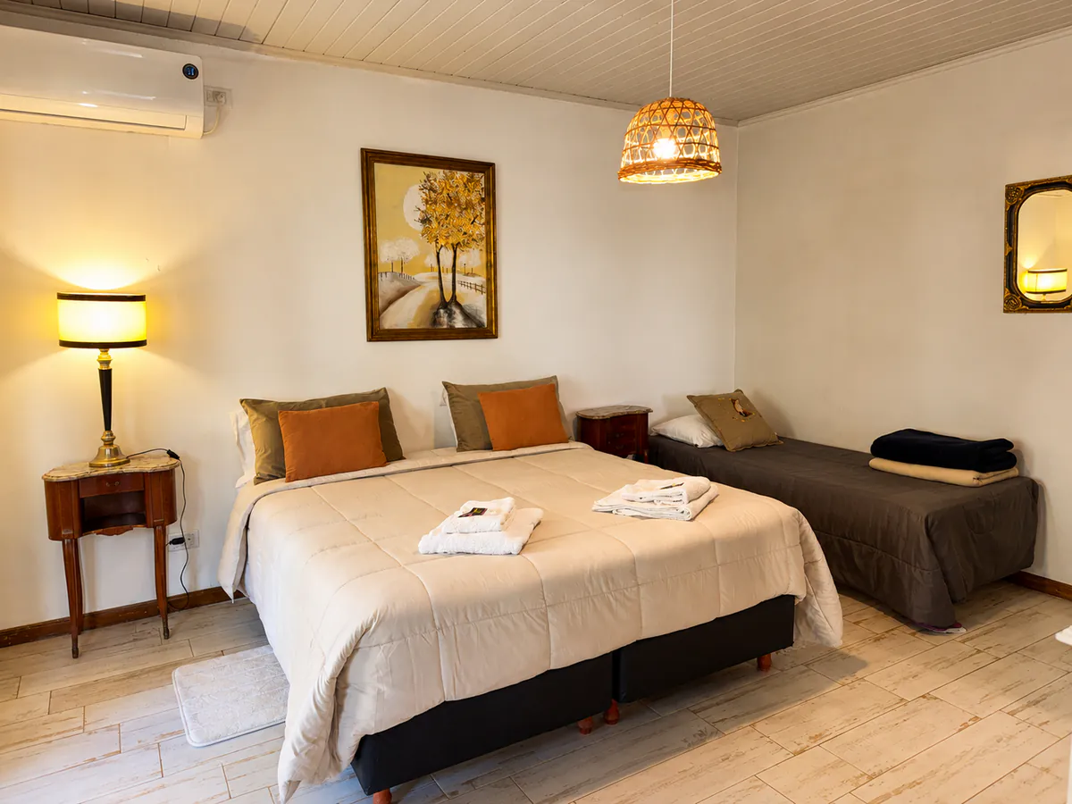 Ambiente de la Suite 11 con cama matrimonial y cama individual