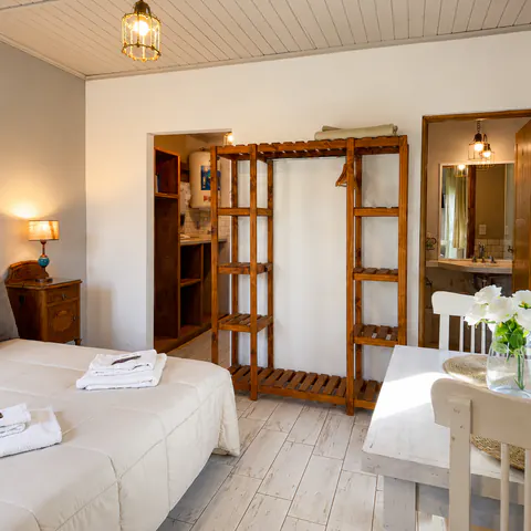 Cama matrimonial de la Suite 13 con acceso a la cocina y el baño